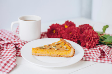 Pumkin pie with seeds on white plate with spoon and napkin