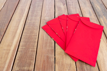 Happy Chinese new year, red envelope or called Angpao on wooden background.