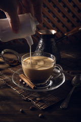 Cup of black coffee on the table with cream