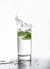 A splash of water caused by lime slices falling into it. Light tonality.