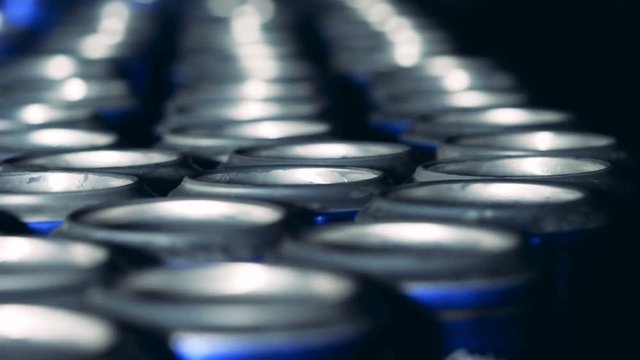 Close up of tin bottoms of beer cans while moving