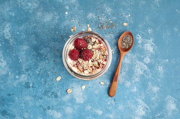 Raspberry chia seed yogurt pudding with muesli and fresh berries
