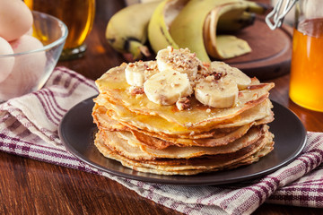 Thin pancakes with banana, walnuts and honey