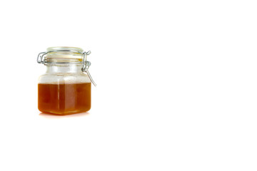 Honey in jar isolated on white background with selective focus