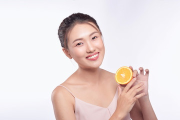 Young asian woman with orange in her hands isolated on white background