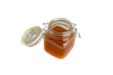 Honey in jar isolated on white background with selective focus