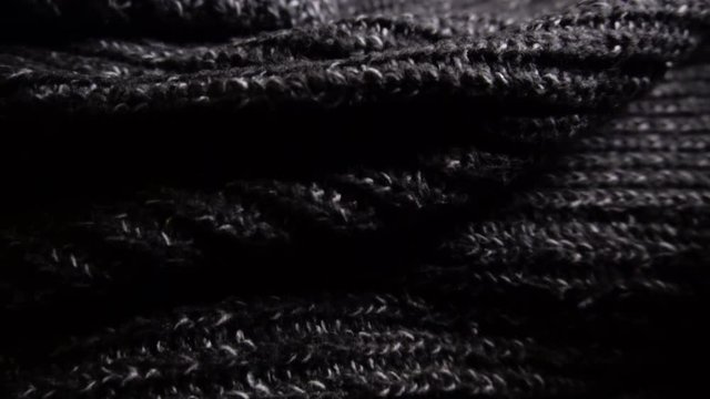 Knitted women's winter sweater in gray. Close-up, slow motion.