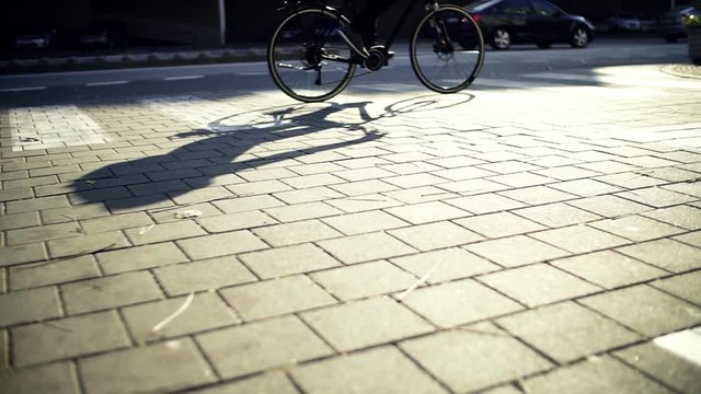 Midsection of male cyclist cycling on an electrobike in city. Slow motion.