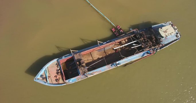 aerial static view of an operation of pumping sand out of a dredging boat through a plastic pipe