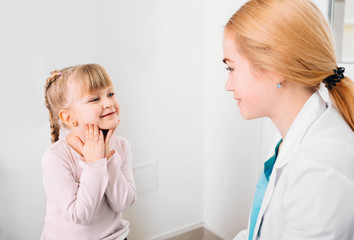 Caring doctor talks with her little patient at clinic