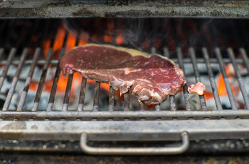 Cooking beef steak on a barbecue grill. Restaurant, chef. Open fire Coal.
