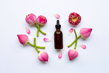 Lotus essential oil with lotus flowers on white.