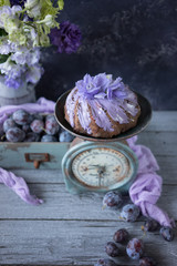 A chocolate cake with lilac flowers and plums