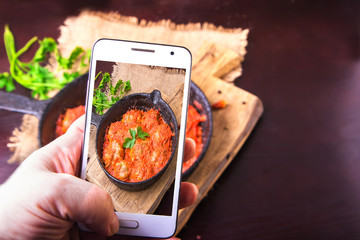 Meatballs in tomato sauce garlic and parsley in an iron frying pan on a dark brown wooden background. Top view. Copy space