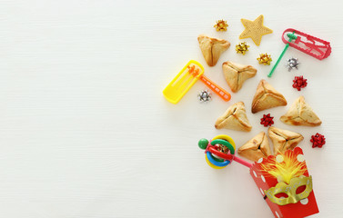 Purim celebration concept (jewish carnival holiday) over white wooden background. Top view, Flat lay.