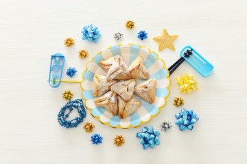 Purim celebration concept (jewish carnival holiday) over white wooden background. Top view, Flat lay.