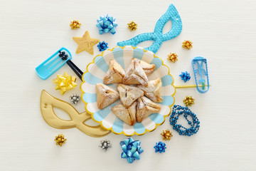 Purim celebration concept (jewish carnival holiday) over white wooden background. Top view, Flat lay.