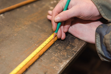 Carpenter measures the details with a measuring tape. Measure details in a carpentry workshop.