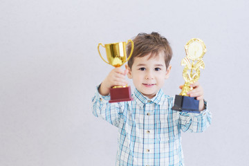 funny boy age three years old, holding in holding a trophy