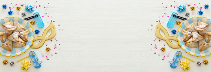 Purim celebration concept (jewish carnival holiday) over white wooden background. Top view, Flat lay.