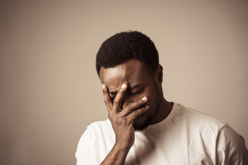 Close up portrait of Unhappy sad young man face suffering from depression and stress