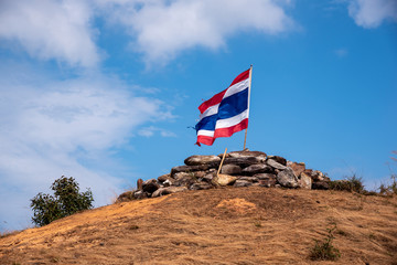 Image of waving Thai flag of Thailand with blue sky and mountain
