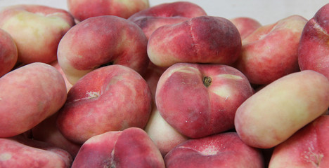 A Collection of Fresh Flat Donut Fruit Peaches.