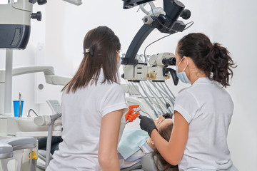 Female dentists diagnosing patient in dentistry clinic.