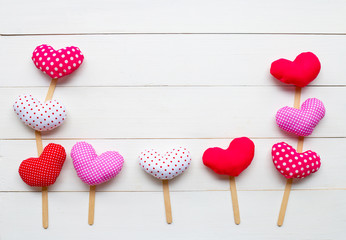 Valentine's hearts on white wooden background.