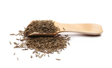 Pile of cumin, caraway seeds in wooden spoon isolated on white background
