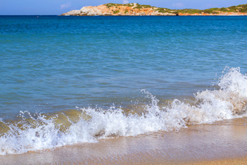 Surf and tide of foamy waves on a sandy beach. Sunny sandy Livadi beach in sea Bay of resort...