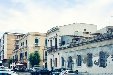 Fototapeta premium View of old street, facades of ancient buildings in seafront of Ortygia (Ortigia) Island, Syracuse, Sicily, Italy.