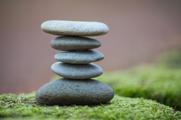 Closeup of stone balance on moss in the forest