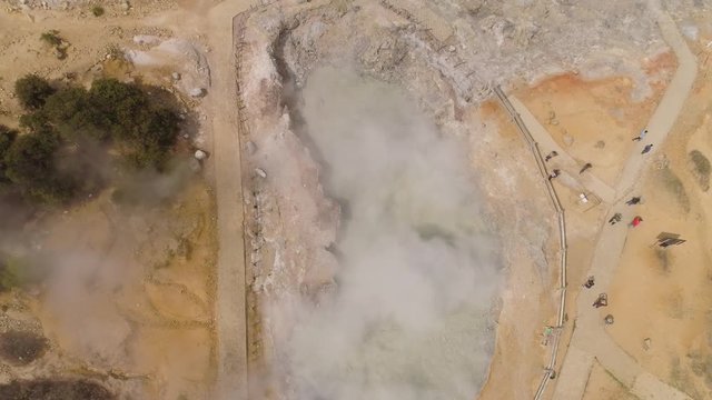 plateau with volcanic activity, mud volcano Kawah Sikidang, geothermal activity and geysers. aerial view volcanic landscape Dieng Plateau, Indonesia. Famous tourist destination of Sikidang Crater it