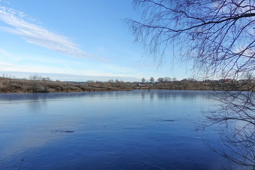 Blue ice on the surface of a forest lake. The snow has not yet fallen. Early winter
