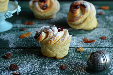 Sweet Cruffins on a green wooden background. Buns from yeast dough sprinkled sugar powder