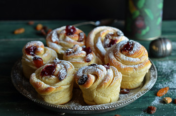 Homemade Cruffins on a metal tray on a wooden background. Sweet Cruffins sprinkled sugar powder