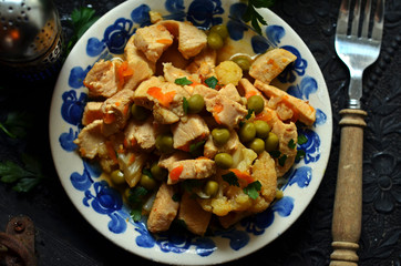 Chicken with peas and cauliflower on a rustic plate