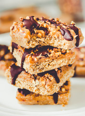 Organic homemade granola bars with date caramel and chocolate on white marble background.Close-up.Tone.