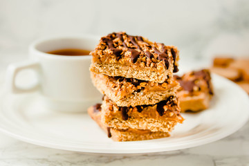 Paleo chocolate energy bars with rolled oats, nuts, dates caramel, chia seeds and coconut flakes. Horizontal.