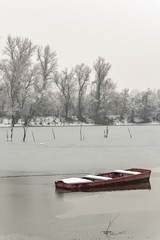 Naklejka premium Beautiful frozen river. A boats covered with snow.
