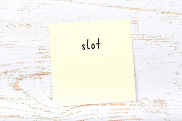 Yellow sticky note with handwritten text slot