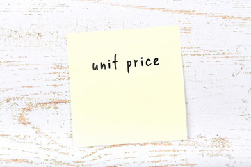 Yellow sticky note with handwritten text unit price