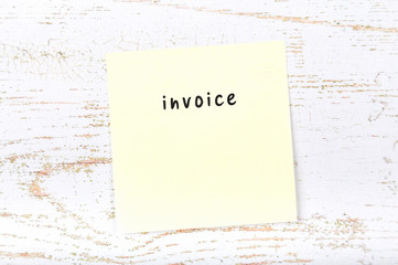 Yellow sticky note with handwritten text invoice