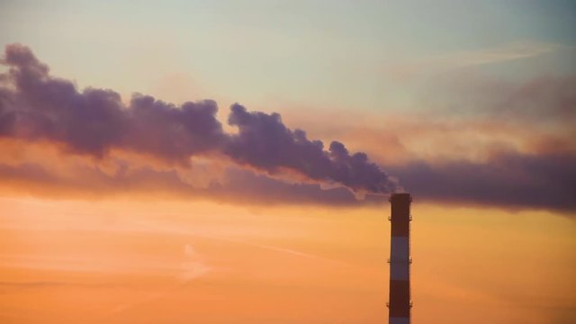 Lonely factory pipe polluting air against sunset, environmental problems, smoke from chimneys