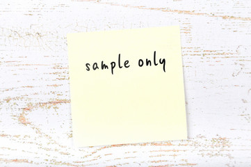 Yellow sticky note with handwritten text sample only