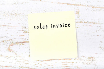 Yellow sticky note with handwritten text sales invoice