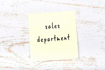 Yellow sticky note with handwritten text sales department