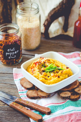 Hummus, chickpea dip, with rosemary, smoked paprika and olive oil on a wooden background. Rustic. Healthy lifestyle and balanced food concept.Toning.