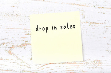 Yellow sticky note with handwritten text drop in sales